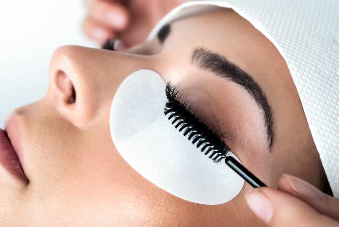 Technician applying lash extensions during a beauty treatment, demonstrating proper lash extension aftercare in action.